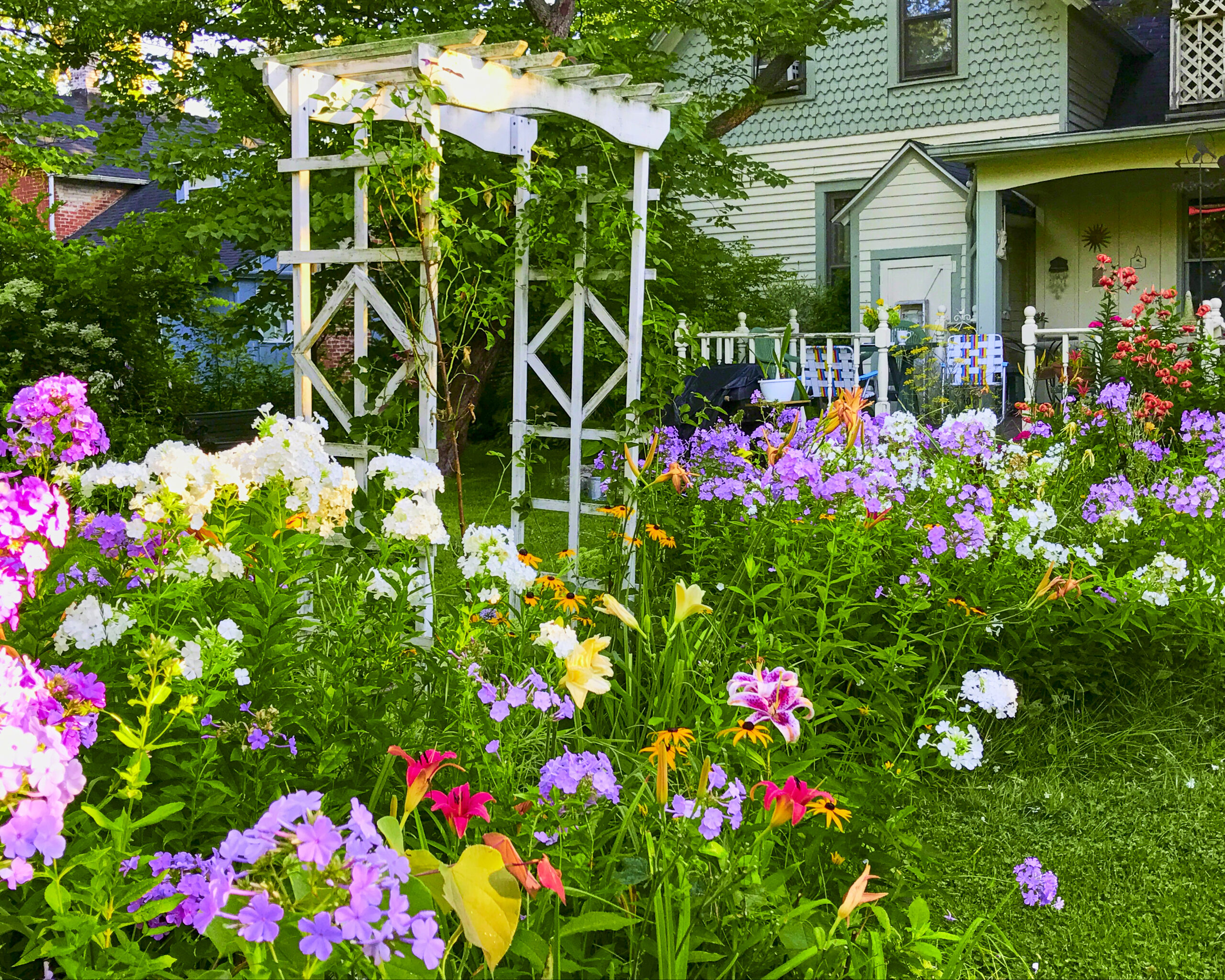 The full summer border with phlox, lilies and arbor